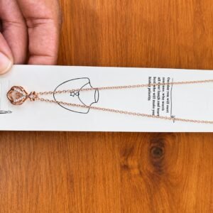 Rose gold-tone crown pendant necklace with clear stone accents
