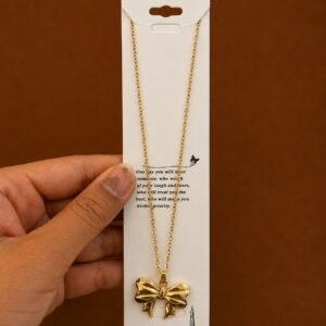 Gold-tone bow pendant necklace with sculpted ribbon detail