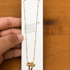 Gold-tone open ribbon bow pendant necklace on a ball-station chain