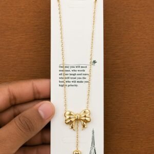 Gold-tone bow pendant necklace with a dangling heart
