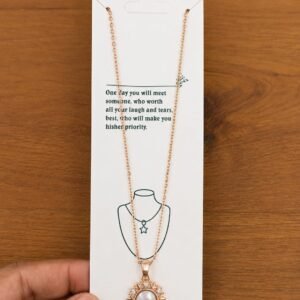 Rose gold-tone sun pendant necklace with a pearl-like center