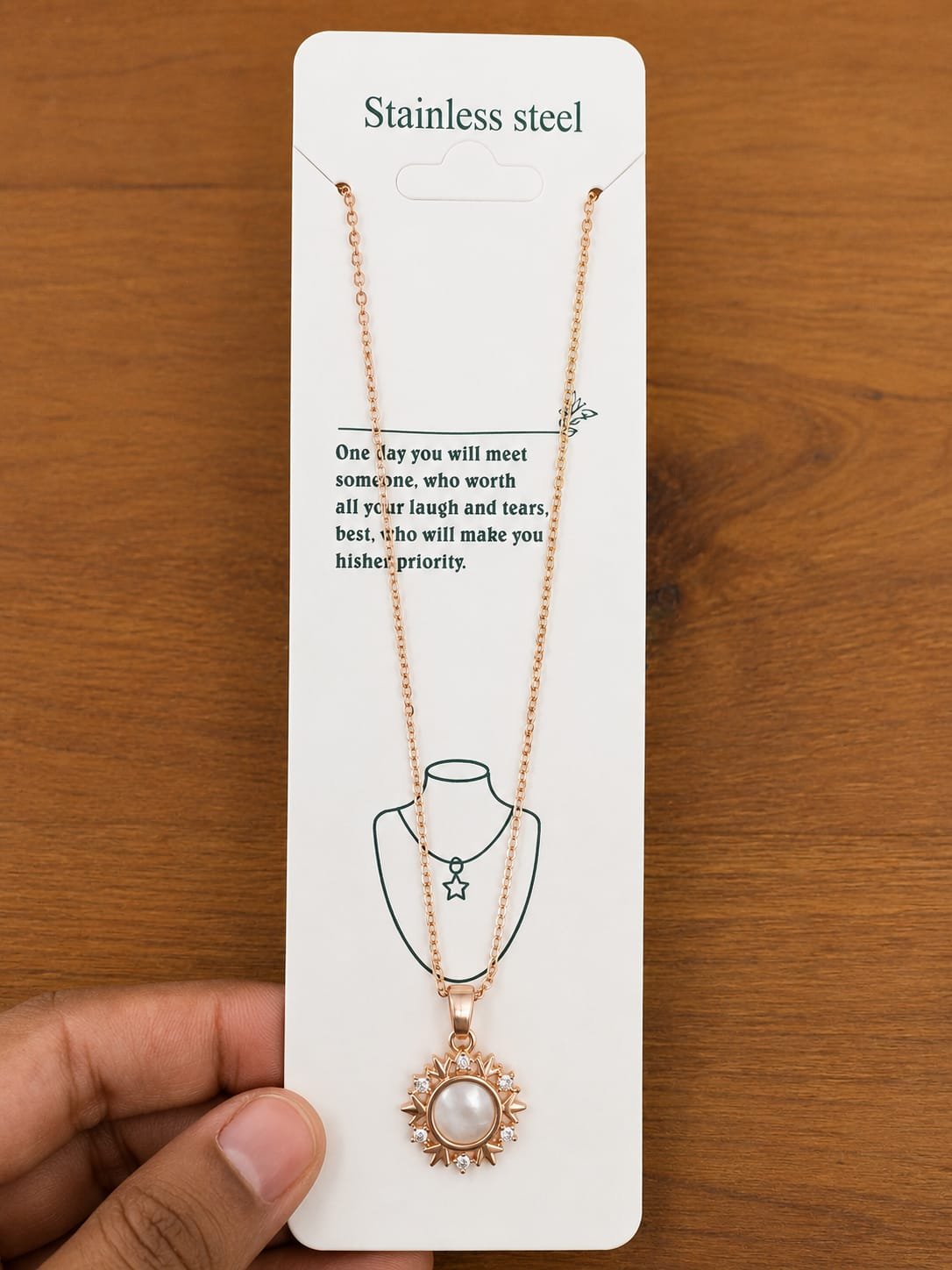 Rose gold-tone sun pendant necklace with a pearl-like center