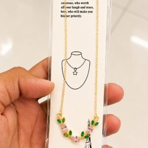 Gold-tone flower necklace with pink stones and green leaf accents