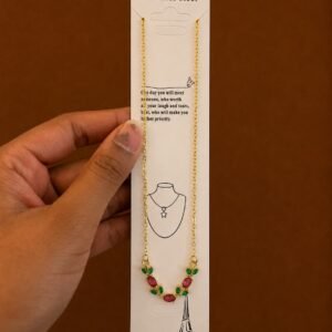 Gold-tone flower necklace with red stones and green leaf accents