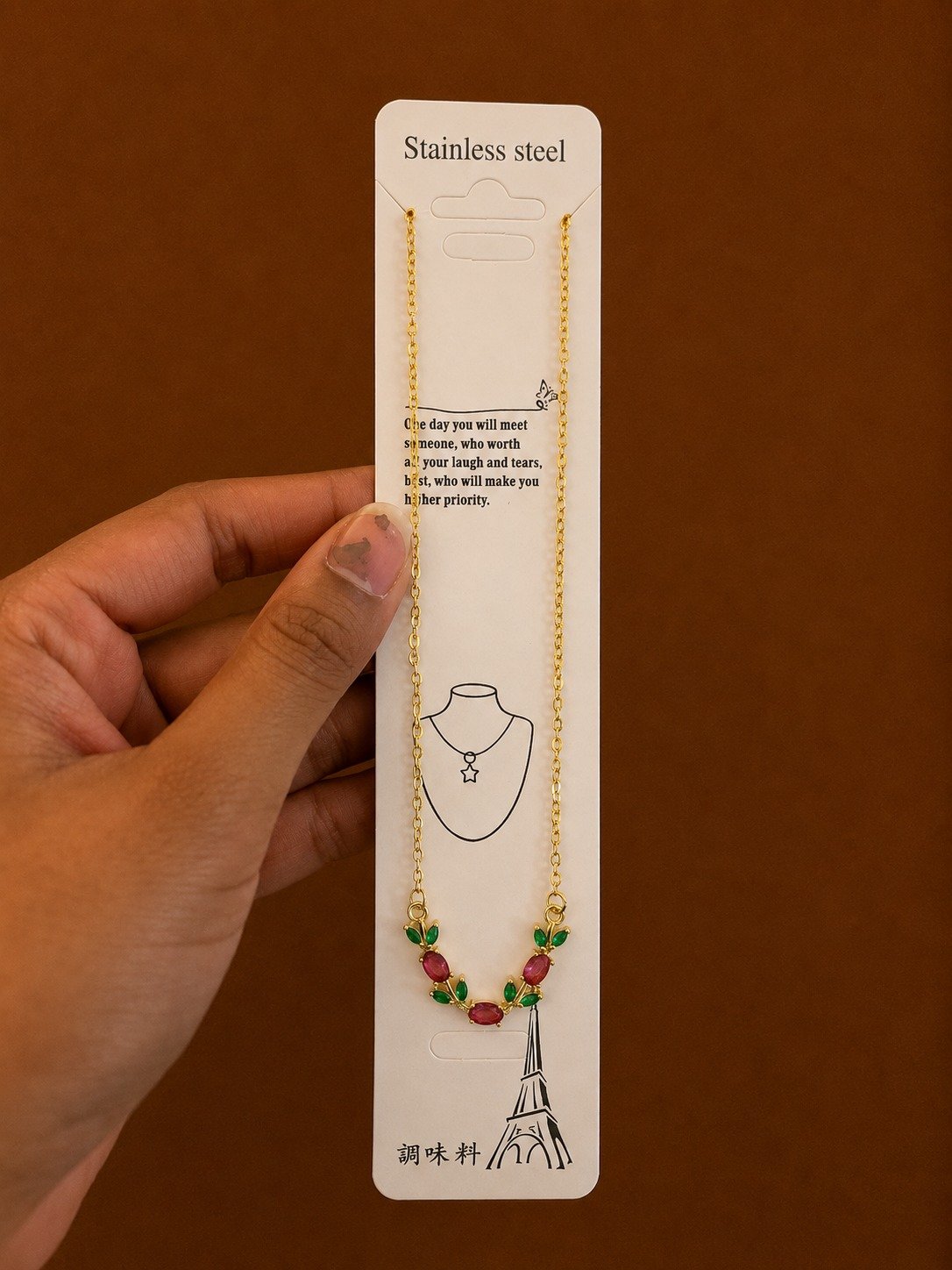 Gold-tone flower necklace with red stones and green leaf accents