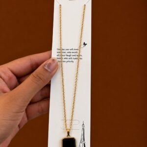 Gold-tone necklace with a glossy black rounded-square pendant