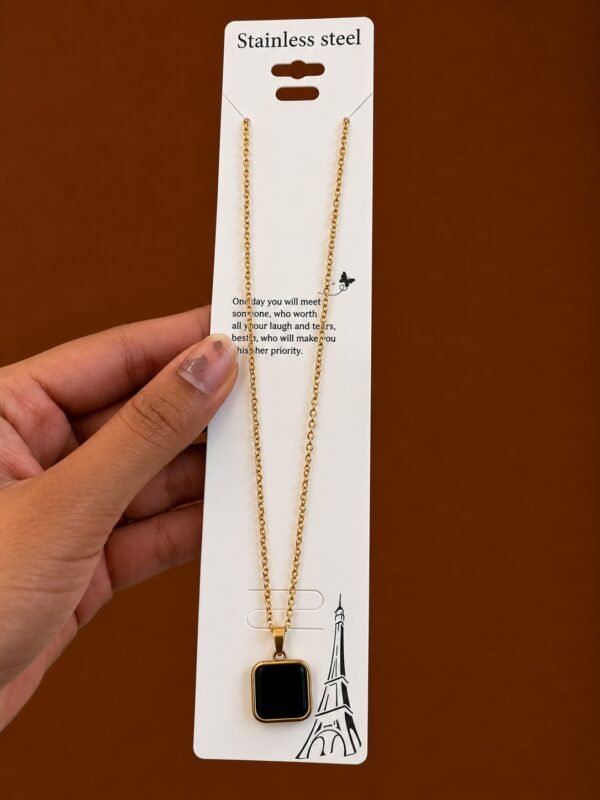 Gold-tone necklace with a glossy black rounded-square pendant